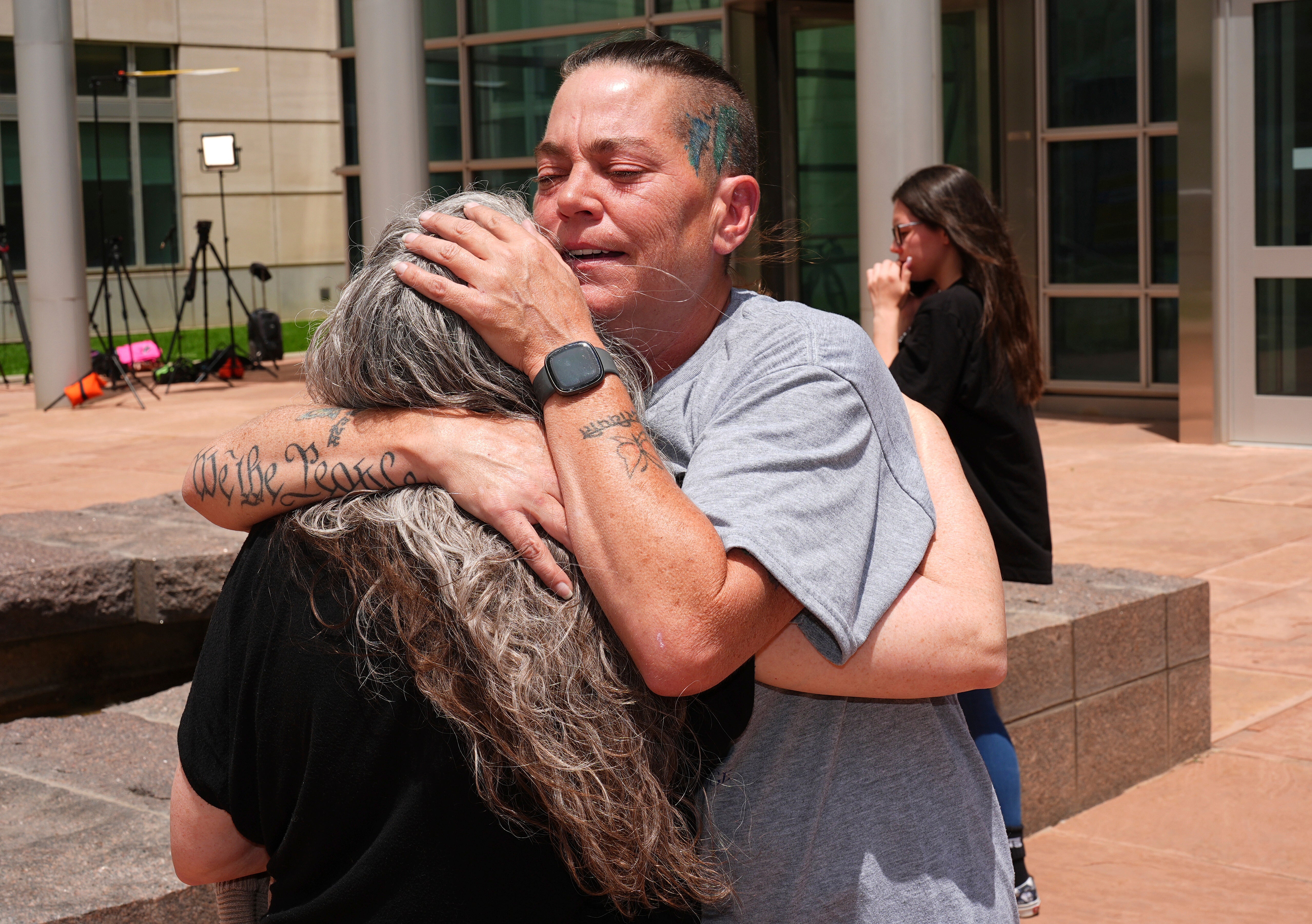 Crystina Page, right, hugs Beth Mosley. Both had retained Jon Hallford’s services