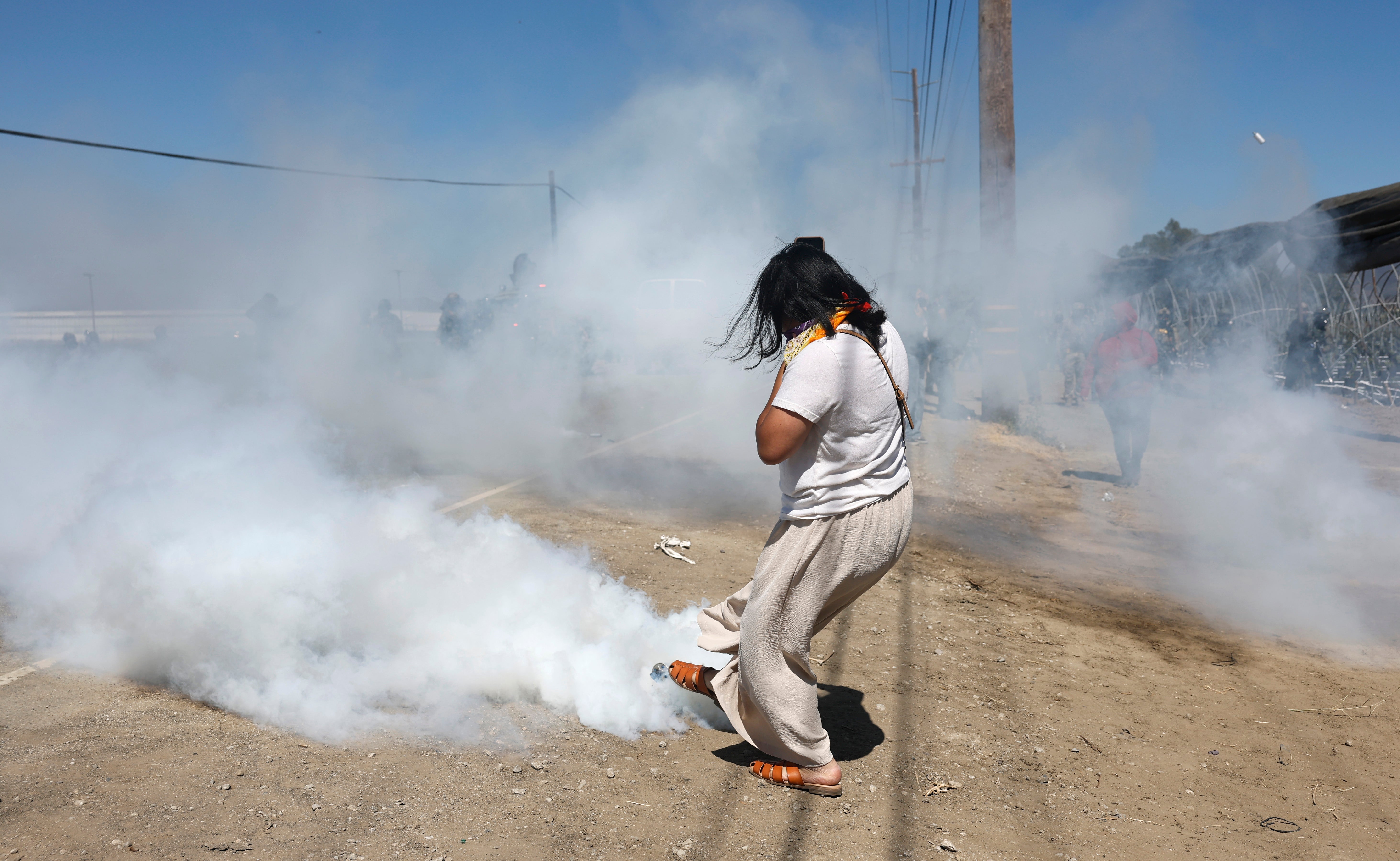 Masked federal agents fired tear gas into crowds at the scene and arrested several people, including a university professor and U.S. citizen accused of assaulting officers