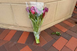 A bouquet sits outside the CVS where police say a gunman killed a police officer and fired several rounds at the CDC campus
