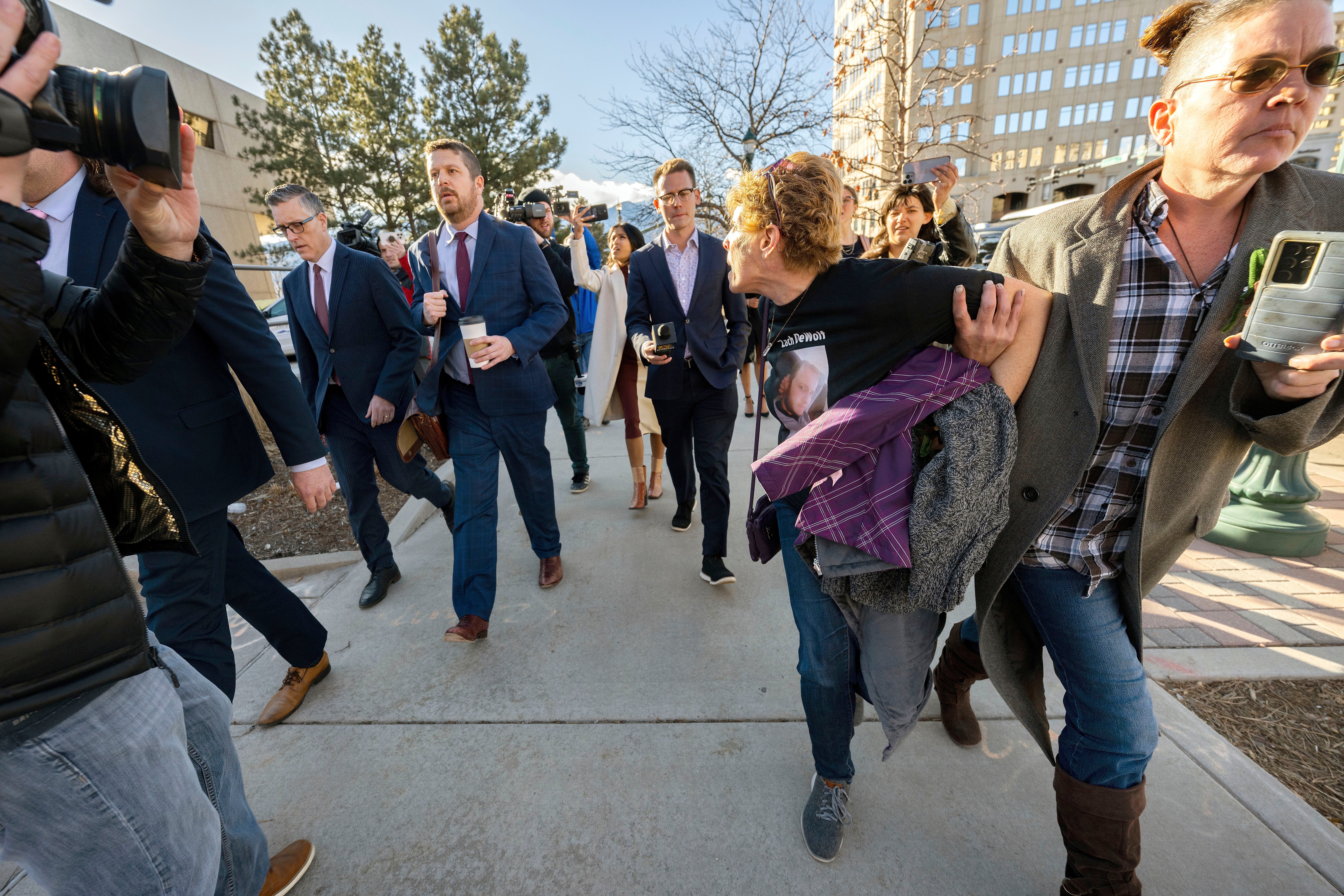Chrystina Page, right, holds back Heather De Wolf, as she yells at Jon Hallford, left, the owner of Back to Nature Funeral Home, as he leaves with his lawyers following a preliminary hearing, Thursday, Feb. 8, 2024, outside the El Paso County Judicial Building in Colorado Springs, Colo. (Christian Murdock/The Gazette via AP, File)
