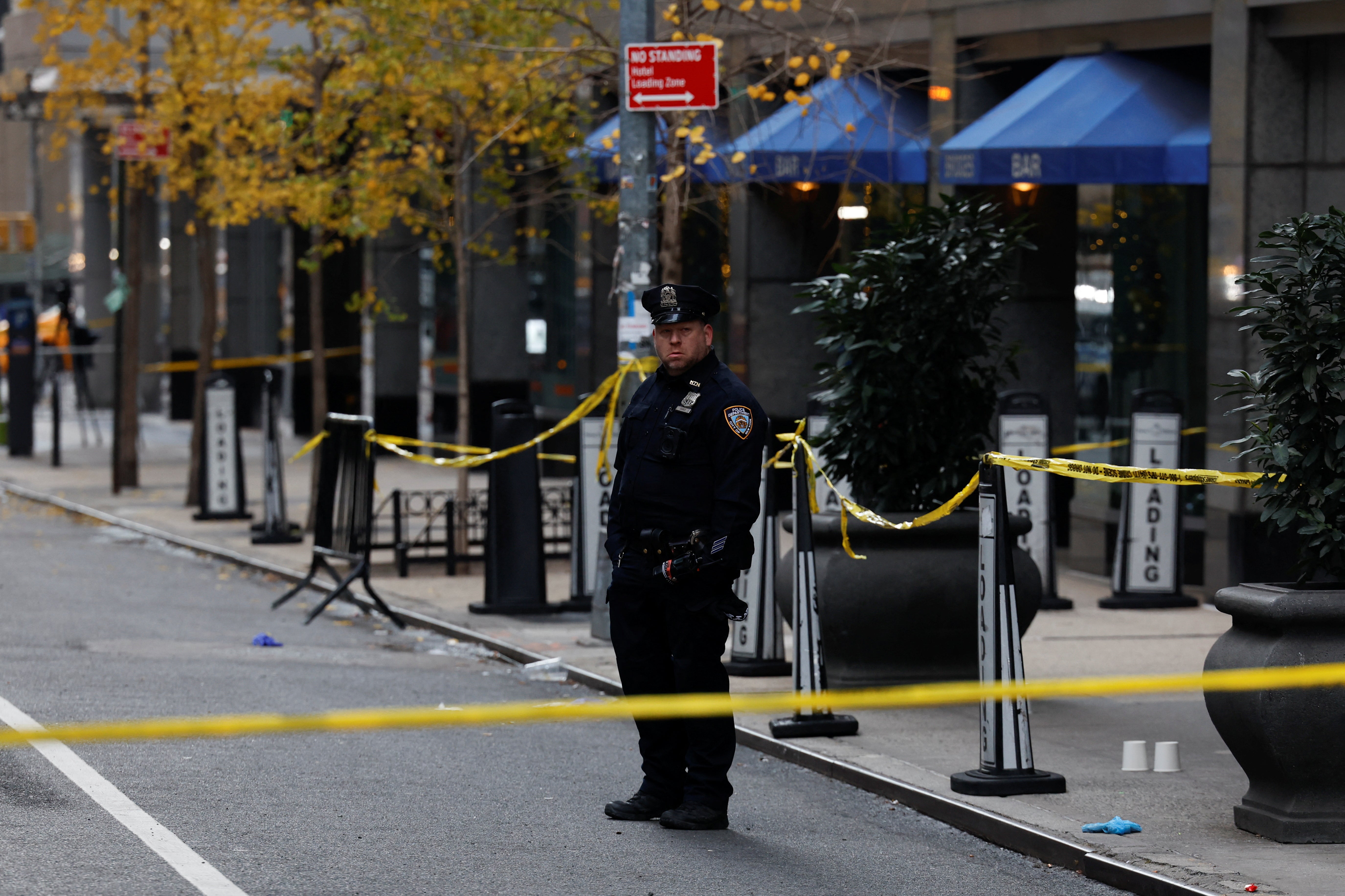A police officer stands near the scene where the CEO of United Healthcare Brian Thompson was shot and killed in Midtown Manhattan, December 4, 2024
