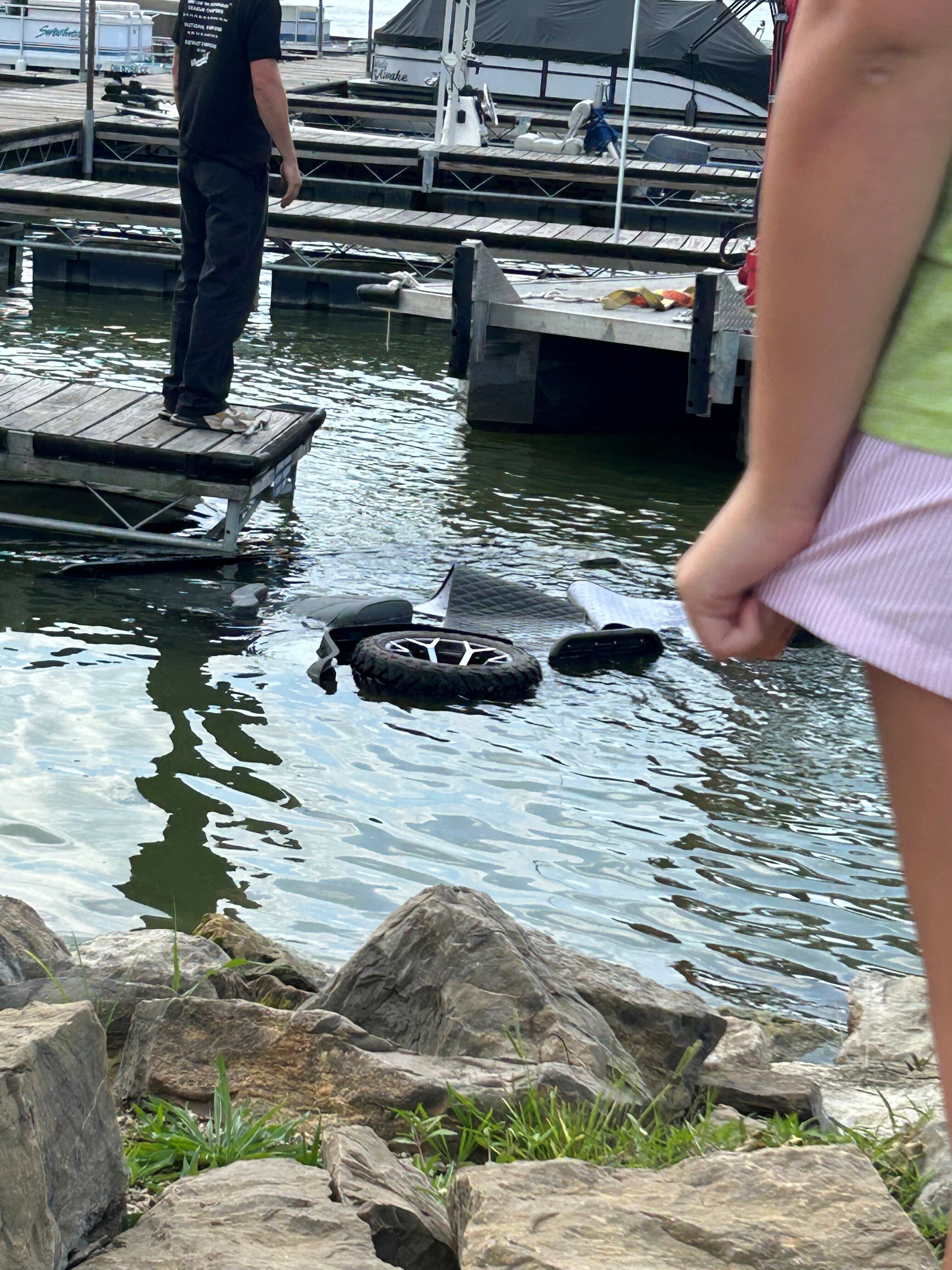 People stand over the site where investigators say 40-year-old Ruth Miller of Millersburg, Ohio, drove a golf cart into Atwood Lake, Ohio Aug. 23, 2025, after she allegedly killed her son by throwing him into the lake. (Tuscarawas County, Ohio, Sheriff's Office via AP)
