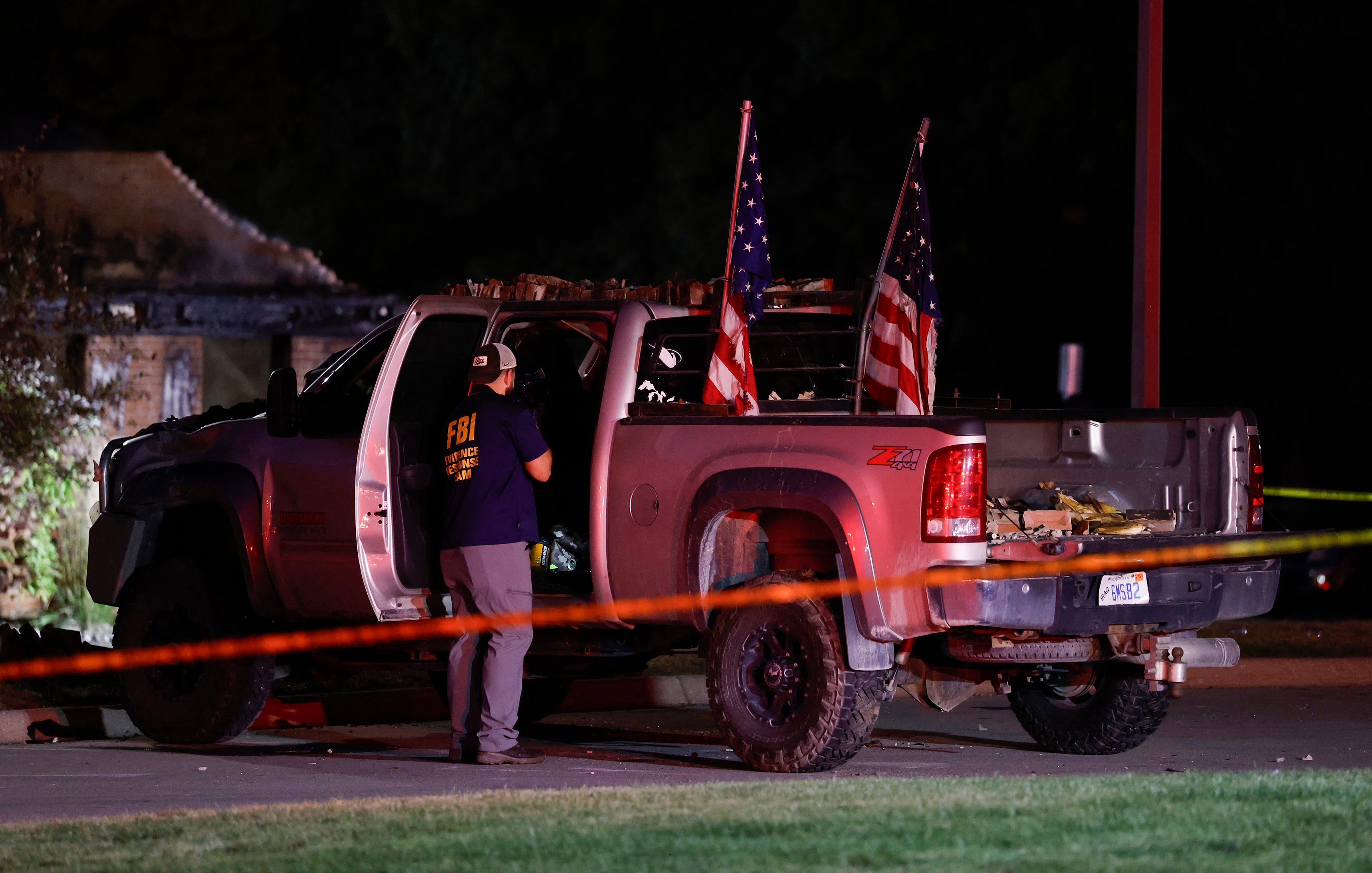 An FBI Evidence Response Team agent inspects the suspect's truck outside the Church of Jesus Christ of Latter-day Saints in Grand Blanc, Michigan