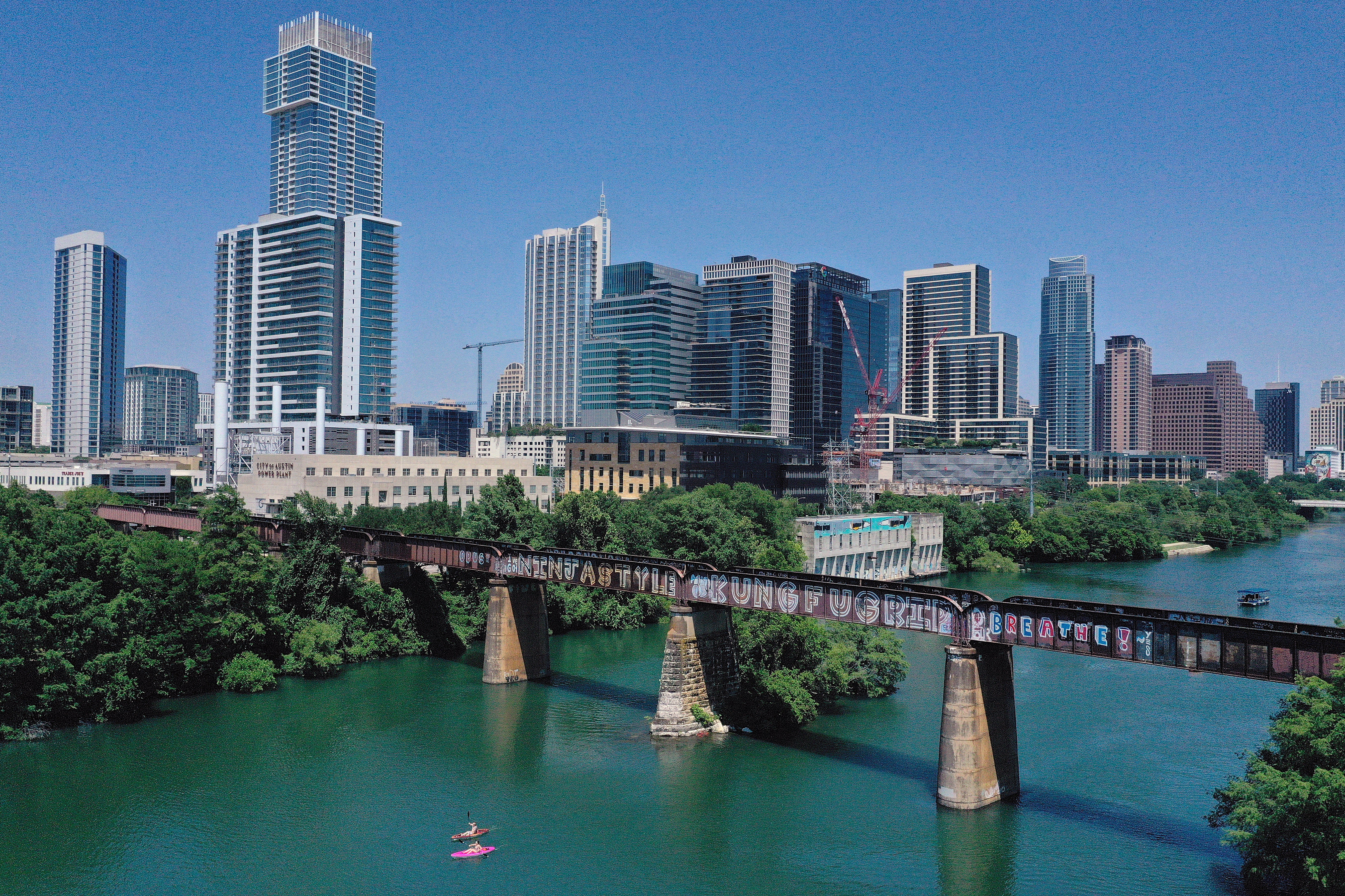 In this aerial view from a drone, residents paddle board and kayak in Lady Bird Lake. More than three dozen bodies have been found in and around the lake since 2022